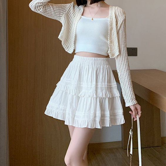 Model wearing a stylish white lace femboy skirt with a cardigan, showcasing a soft and elegant look for femboy fashion lovers.
