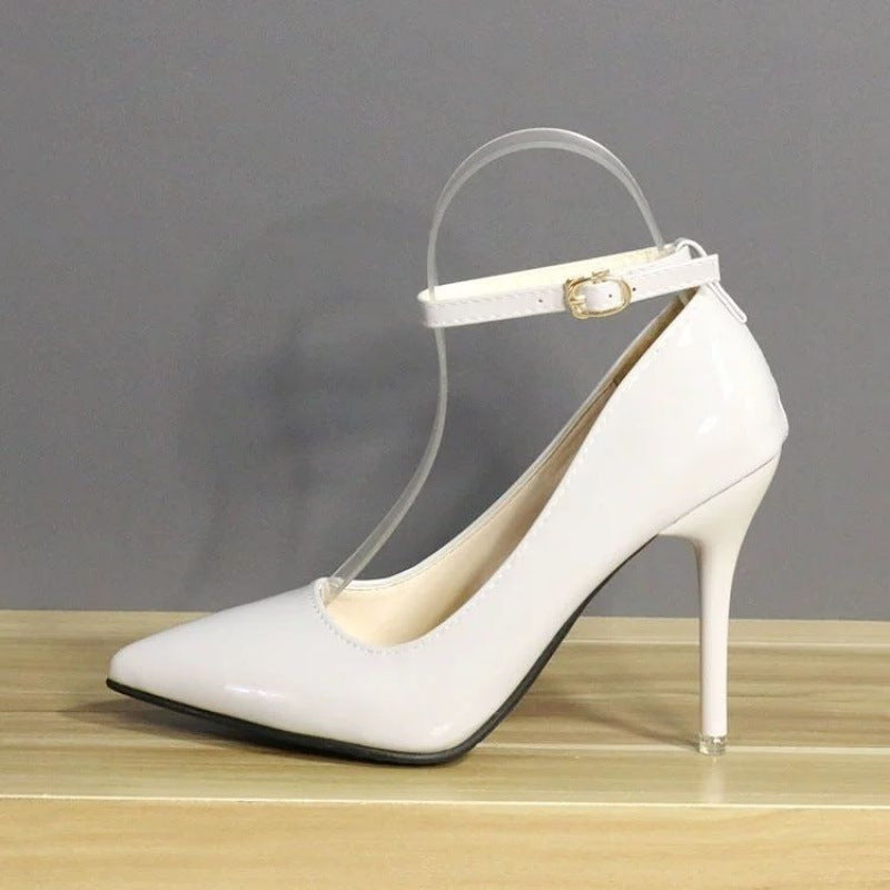 Side view of elegant white leather heels featuring a 10 cm slim heel and secure ankle strap, set against a grey backdrop. Ideal for office wear or sophisticated femboy fashion.