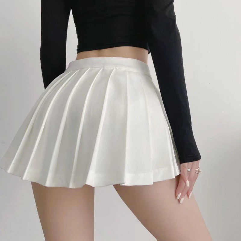 Close-up view of a stylish white pleated half skirt against a black top, highlighting its high waist and flared design that's perfect for a trendy femboy outfit.